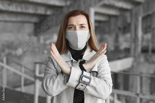 A masked woman shows a stop sign for the coronavirus. The 2020 pandemic. Stop the covid19. Quarantine. Coronavirus.