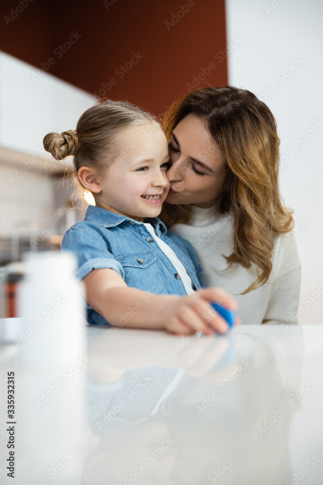 Pretty Caucasian mother kissing her daughter in hospital Pretty Caucasian mother kissing her daughter in hospital