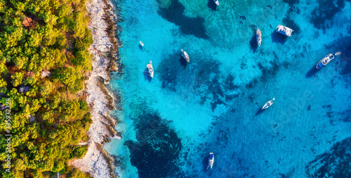 View on the boats from drone. Blue water background and coast with forest from top view. Summer seascape from air. Croatia. Travel - image