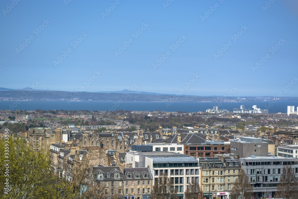 View of Edinburgh city center, downtown with historic buildings and trees vegetation around, in Scotland