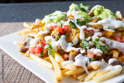 Canvas Print A closeup view of a plate of carne asada fries, in a restaurant or kitchen setting