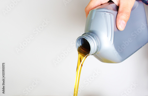 Bild auf Leinwand automotive oil in a hand a gray bottle on a light background