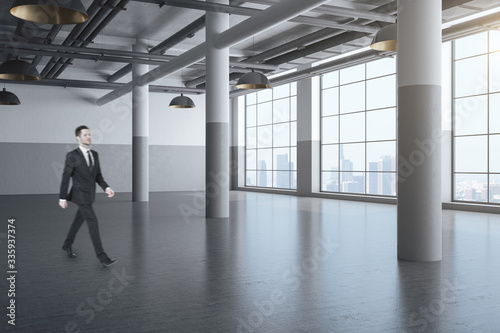 Businessman walking in hall with columns