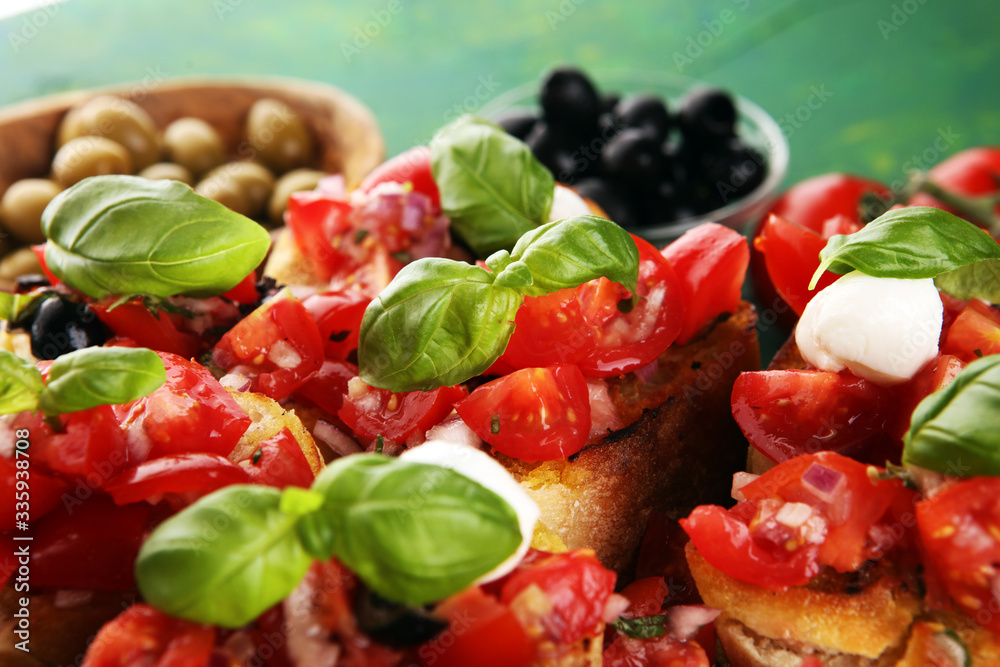 Bruschettas on cutting board on rustic background with tomatoes and basil