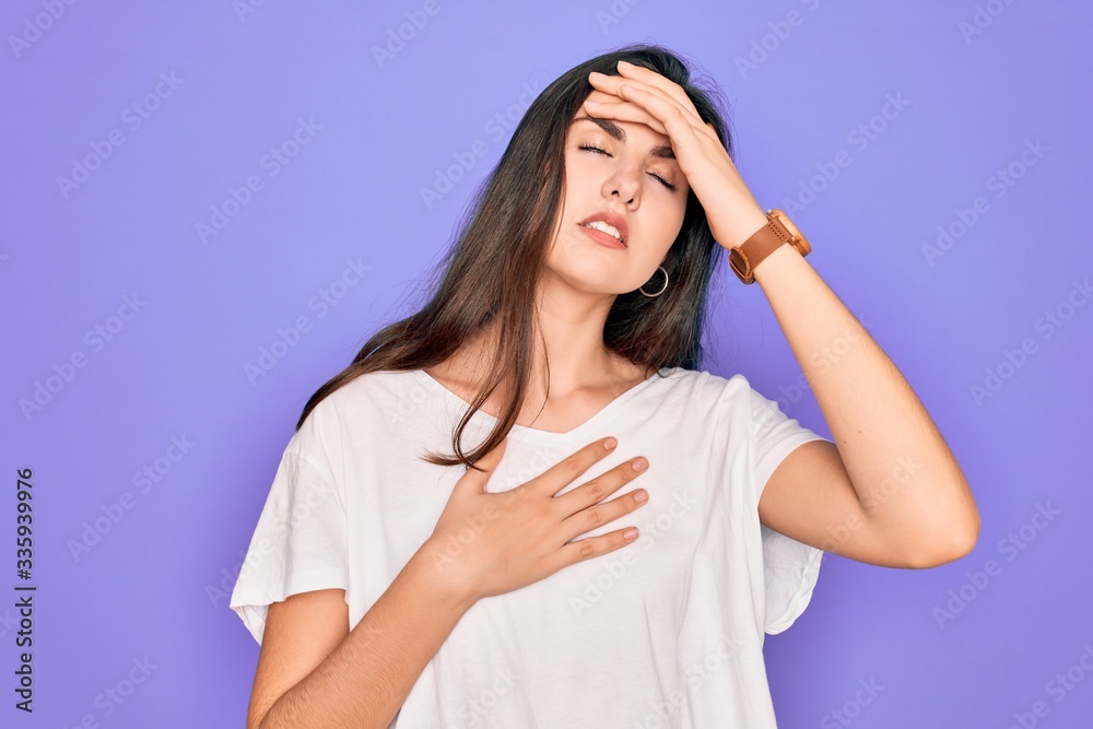 Young beautiful brunette woman wearing casual white t-shirt over purple background Touching forehead for illness and fever, flu and cold, virus sick Young beautiful brunette woman wearing casual white t-shirt over purple background Touching forehead for illness and fever, flu and cold, virus sick