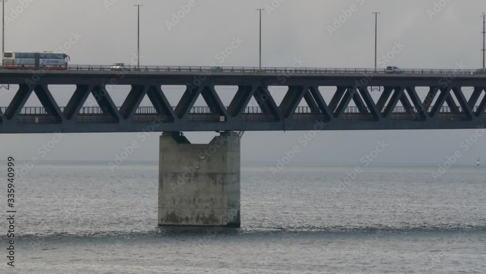 Long shot of Oresund Bridge over the sea, the borden between Sweden and Denmark with a cloudy blue sky in background Long shot of Oresund Bridge over the sea, the borden between Sweden and Denmark with a cloudy blue sky in background