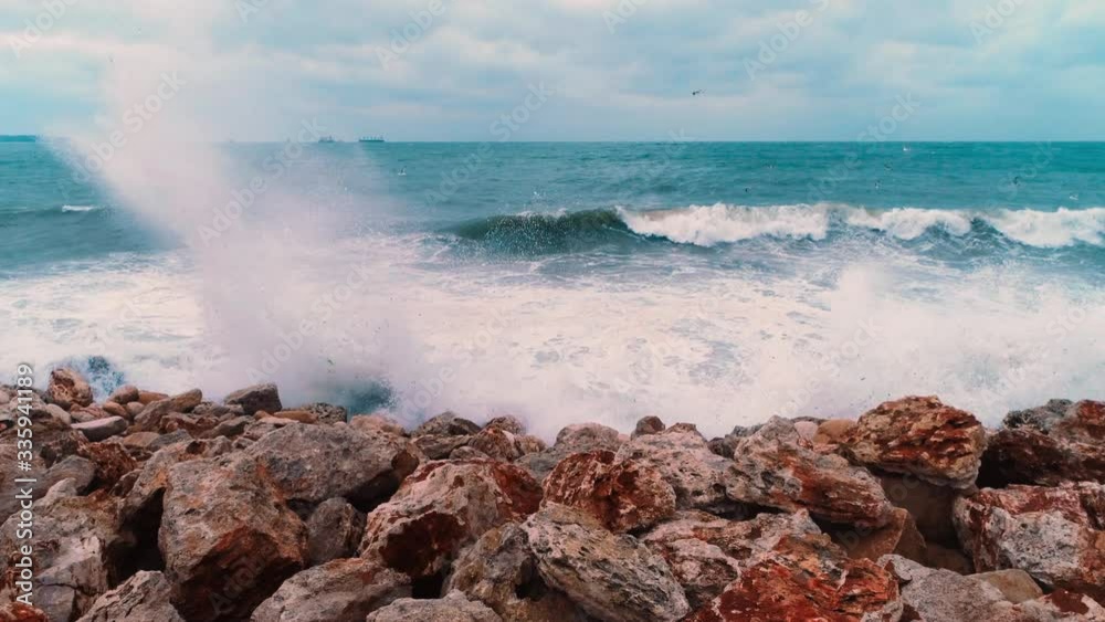 Aerial top view of sea waves hitting rocks on the beach 
