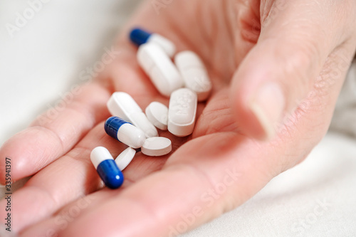 medicine, healthcare and people concept - close up of senior woman hand with pills .