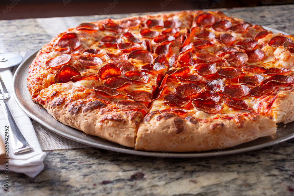 A view of pepperoni pizza pie in a restaurant or kitchen setting.