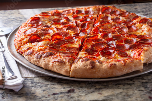 A view of pepperoni pizza pie in a restaurant or kitchen setting.