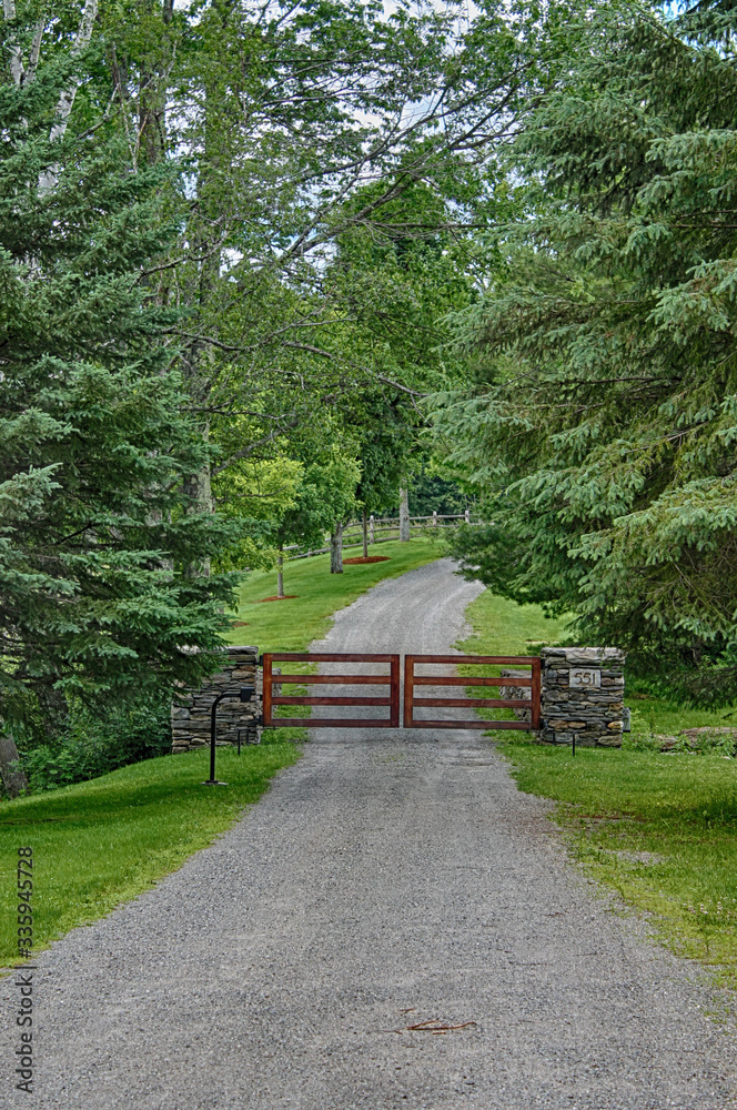 private residence driveway with closed gate in forest on gravel road private residence driveway with closed gate in forest on gravel road