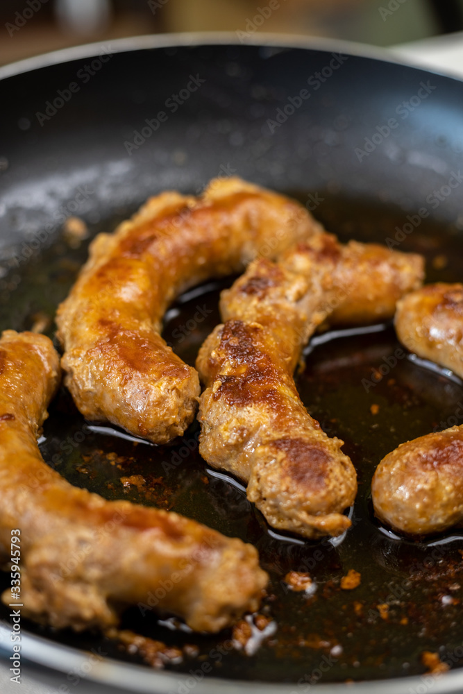 Fried Sausages in the frying pan with blurred background Fried Sausages in the frying pan with blurred background