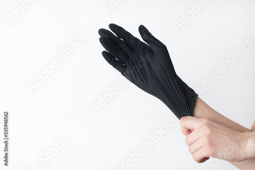 hand black gloves of doctor or hair stylist on white background. gloves are worn on the arm