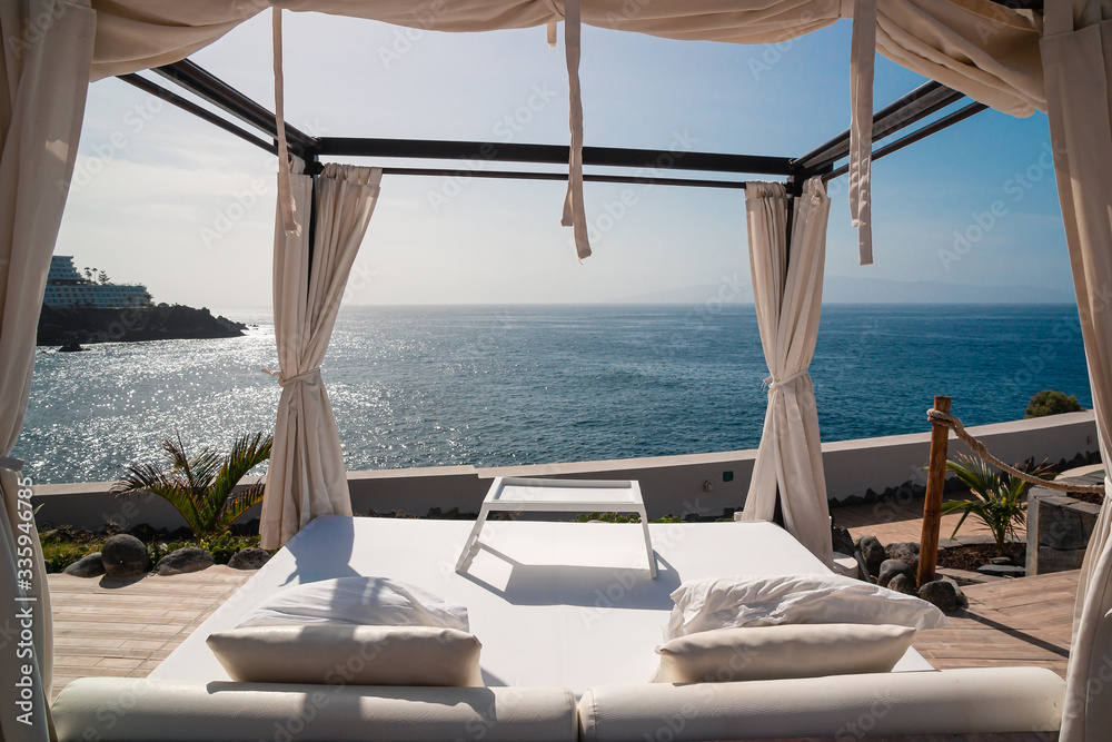 Sunbathing bed in a luxury pool hotel with stunning ocean views