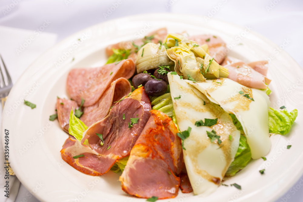 A view of a plate of antipasto salad, in a restaurant or kitchen setting. A view of a plate of antipasto salad, in a restaurant or kitchen setting.