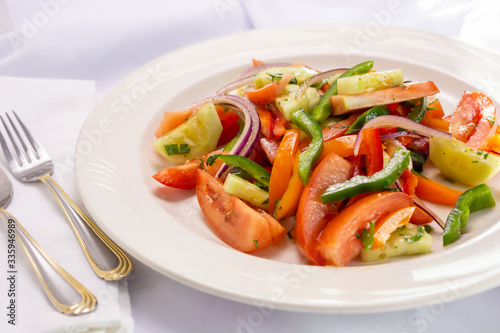 A view of a plate of Italian tomato salad, in a restaurant or kitchen setting.