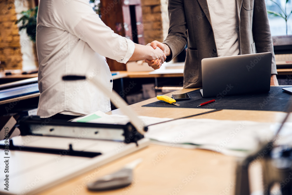 Business partners are shaking hands in office