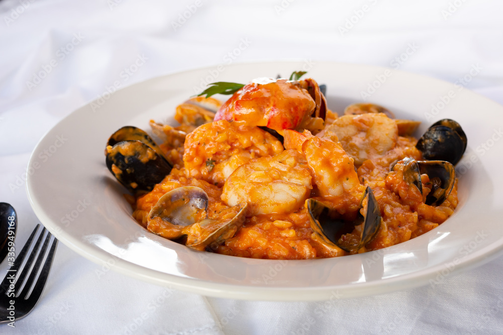 A view of a bowl of seafood risotto, in a restaurant or kitchen setting.