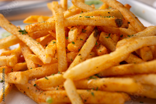 Fototapeta A closeup view of a tray of cajun style french fries in a restaurant or kitchen setting
