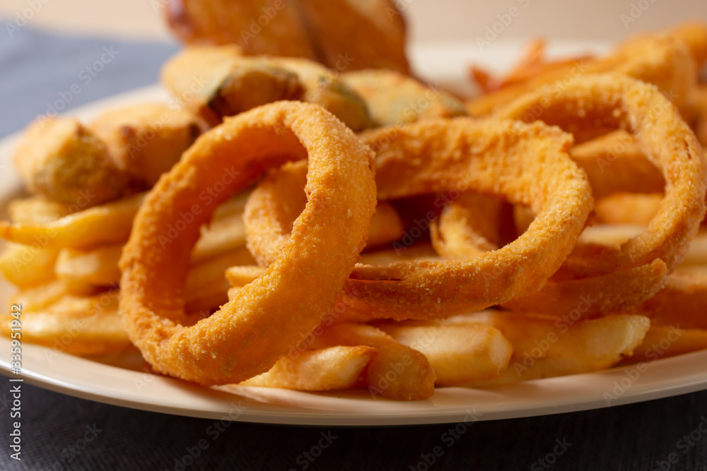 A view of a plate of deep fried appetizers, in a restaurant or kitchen setting. A view of a plate of deep fried appetizers, in a restaurant or kitchen setting.