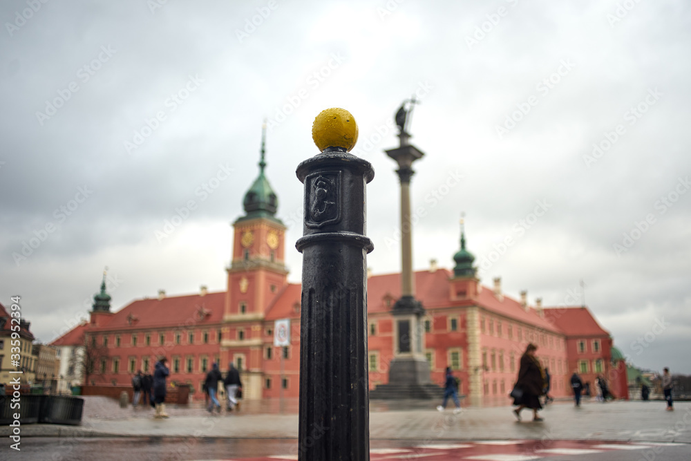 Obraz premium Street pole with Royal Castle of Warsaw in a background.