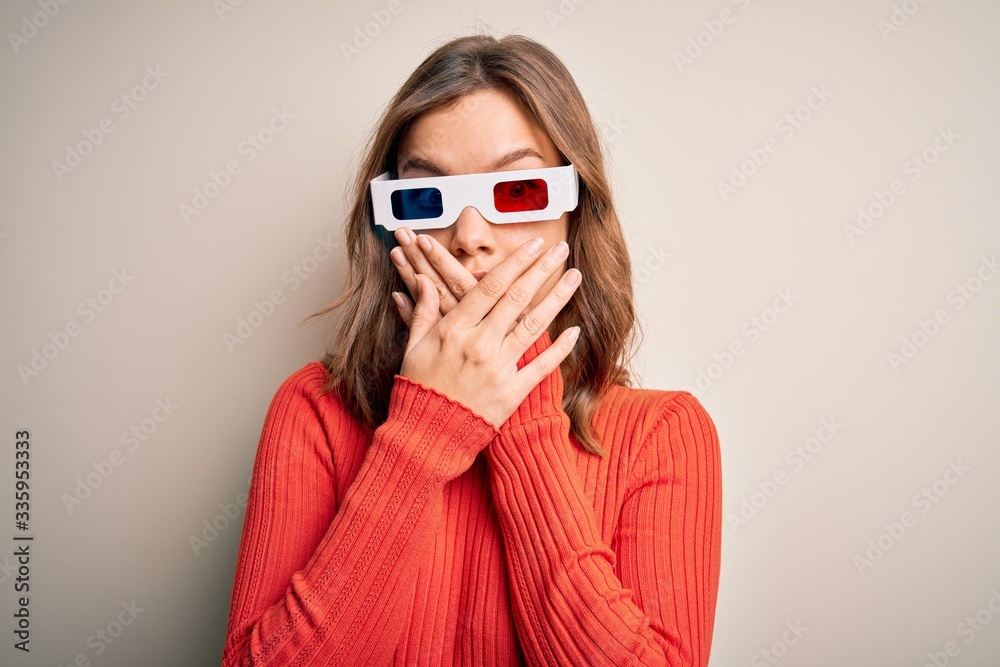 Young blonde girl wearing 3d cinema glasses over isolated background shocked covering mouth with hands for mistake. Secret concept. Young blonde girl wearing 3d cinema glasses over isolated background shocked covering mouth with hands for mistake. Secret concept.
