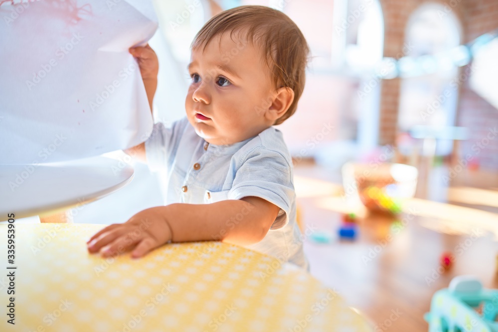 Adorable toddler standing around lots of toys at kindergarten Adorable toddler standing around lots of toys at kindergarten