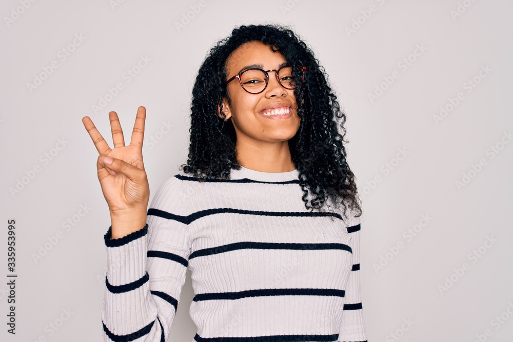 Young african american woman wearing striped sweater and glasses over white background showing and pointing up with fingers number three while smiling confident and happy.