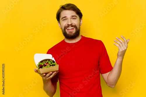 young man holding a plate with vegetables