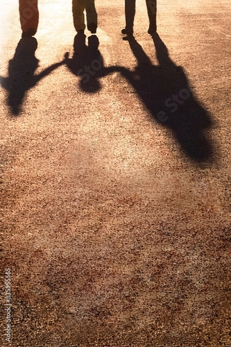 Silhouettes of people holding hands together. Shadow on the pavement on a sunny day. Friendship and relationship concept