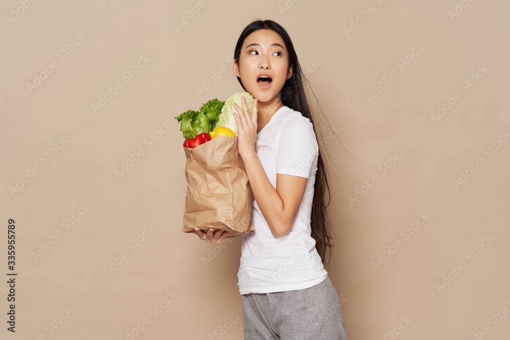young woman holding a shopping bag full of groceries young woman holding a shopping bag full of groceries