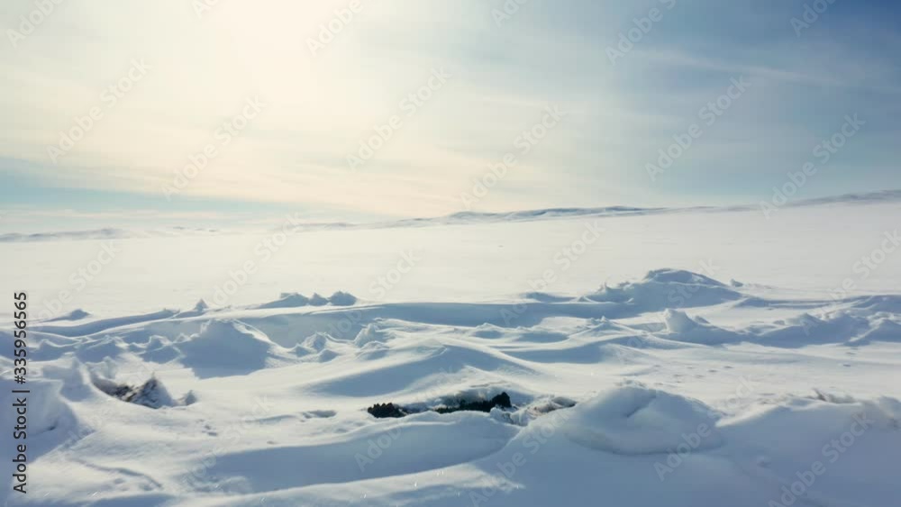 Snowy mounds landscape on a winter sunny day with ravine. Aerial drone shot Snowy mounds landscape on a winter sunny day with ravine. Aerial drone shot