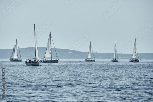Beautiful sea landscape with sailboats, the race of sailboats on the horizon, a regatta, a Intense competition, bright colors, island with windmills are on background