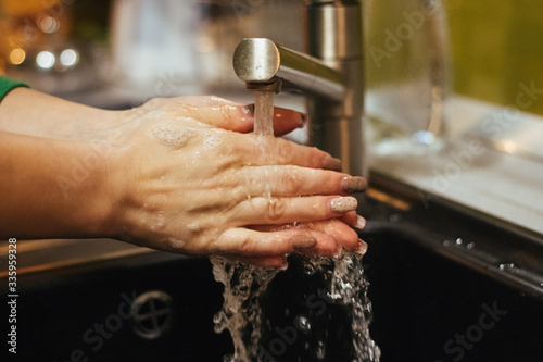 A woman washes hands with soap. Hygiene concept. Closeup