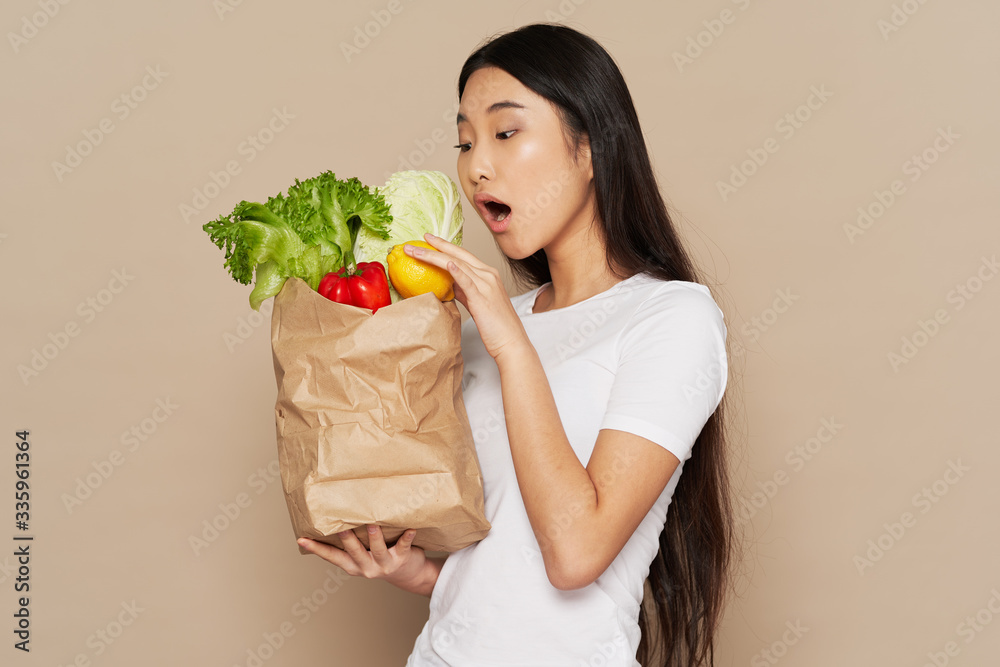 young woman holding a shopping bag full of groceries young woman holding a shopping bag full of groceries