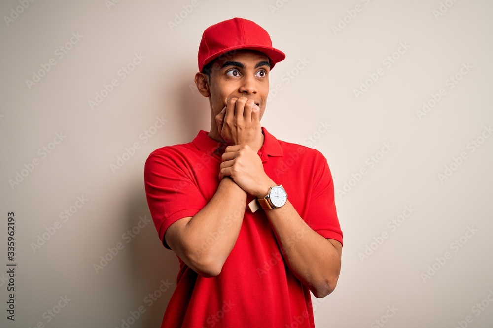 Young handsome african american man wearing casual polo and cap over red background looking stressed and nervous with hands on mouth biting nails. Anxiety problem.