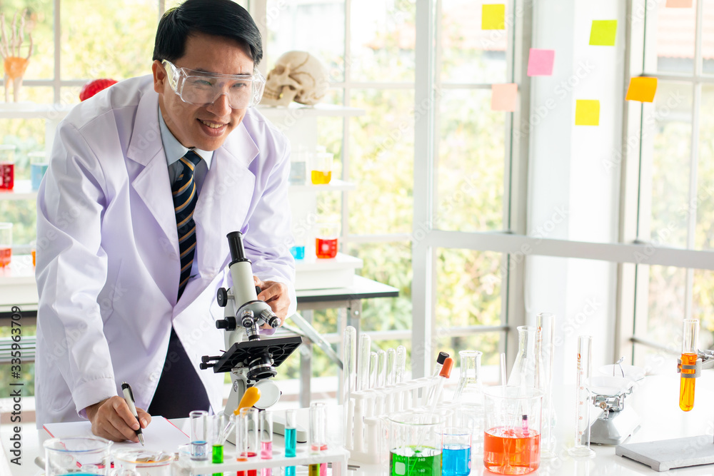 Asian male scientist look through the microscope in the laboratory. Asian male scientist look through the microscope in the laboratory.