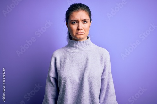 Young beautiful woman with blue eyes wearing casual turtleneck sweater over pink background depressed and worry for distress, crying angry and afraid. Sad expression.