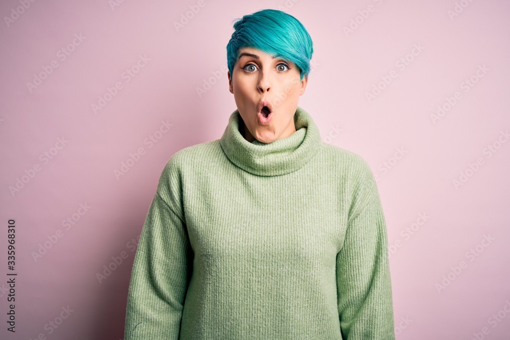 Young beautiful woman with blue fashion hair wearing casual turtleneck sweater afraid and shocked with surprise expression, fear and excited face. Young beautiful woman with blue fashion hair wearing casual turtleneck sweater afraid and shocked with surprise expression, fear and excited face.