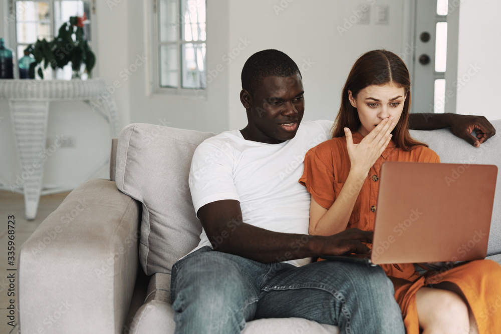 couple sitting on sofa with laptop couple sitting on sofa with laptop