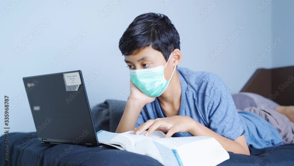 Boy studying with a laptop during quarantine Boy studying with a laptop during quarantine