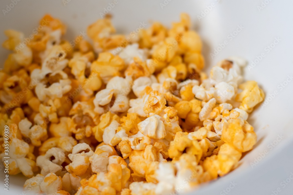 Close up of fresh made popcorn in a white bowl. Entertainment at home concept