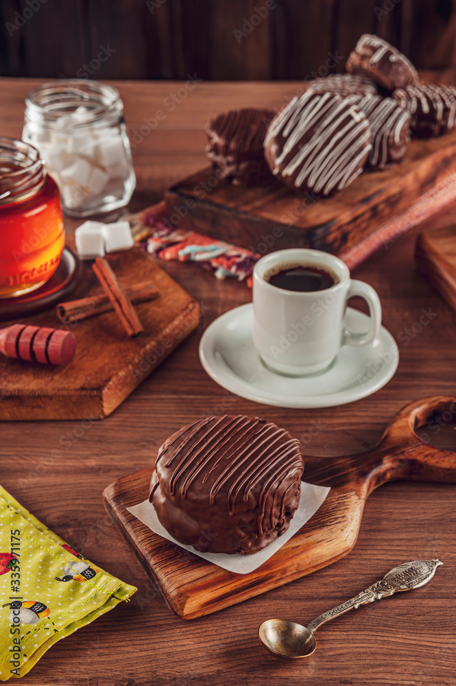 Honey cookie chocolate covered on the wooden table with coffee and various honey breads - pão de mel Honey cookie chocolate covered on the wooden table with coffee and various honey breads - pão de mel