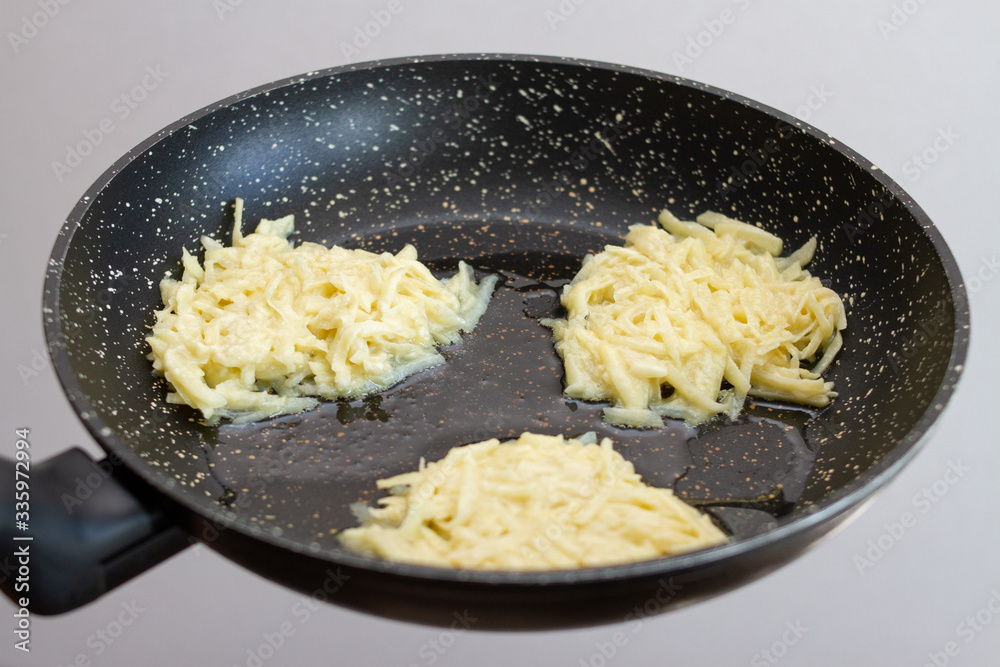 preparation cooking potato pancakes fry in a black pan preparation cooking potato pancakes fry in a black pan