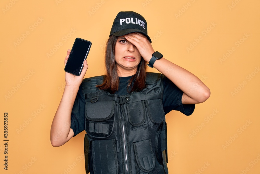 Beautiful brunette policewoman wearing police uniform holding smartphone showing screen stressed with hand on head, shocked with shame and surprise face, angry and frustrated. Fear and upset Beautiful brunette policewoman wearing police uniform holding smartphone showing screen stressed with hand on head, shocked with shame and surprise face, angry and frustrated. Fear and upset