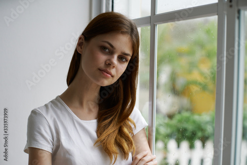 portrait of a young woman looking out window