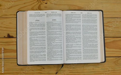 фотографія open bilingual bible book on Joel, Spanish and english