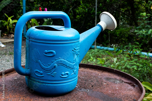blue watering can on rusty tank in the garden.