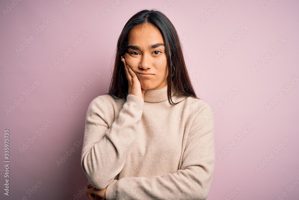 Young beautiful asian woman wearing casual turtleneck sweater over pink background thinking looking tired and bored with depression problems with crossed arms.
