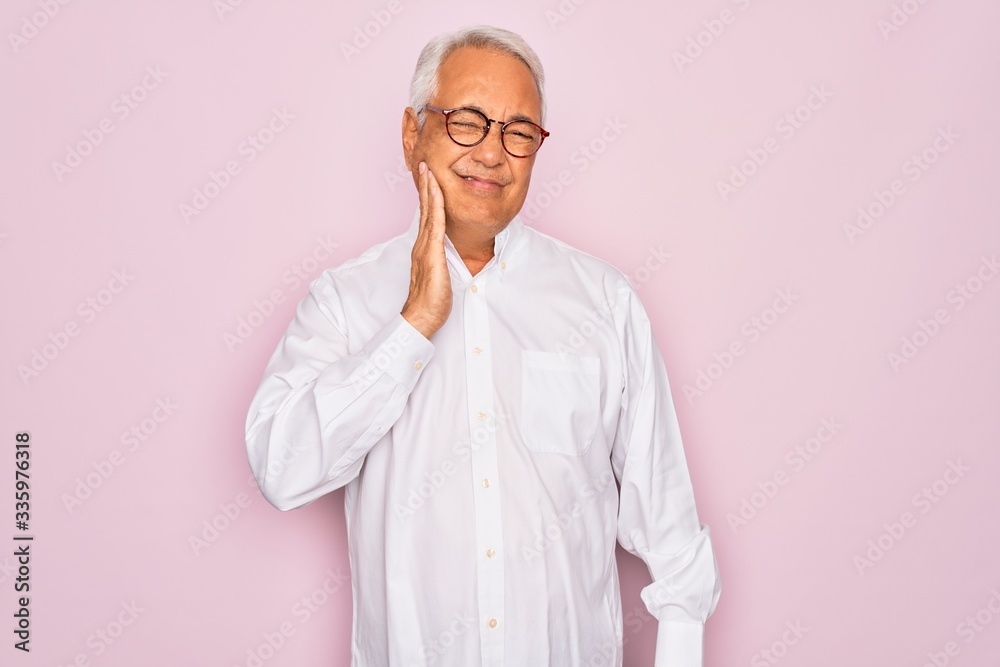Middle age senior grey-haired man wearing glasses and business shirt over pink background touching mouth with hand with painful expression because of toothache or dental illness on teeth. Dentist Middle age senior grey-haired man wearing glasses and business shirt over pink background touching mouth with hand with painful expression because of toothache or dental illness on teeth. Dentist